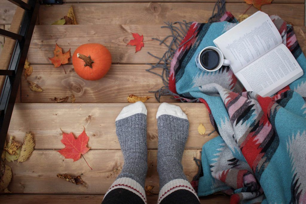 Feet, coffee and book, viewed from above